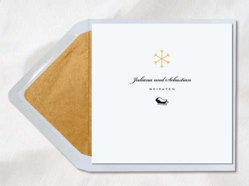 Quadratische Einladung für eine Hochzeit im verschneiten Winter – edel und elegant, mit gold glitzernder Schneeflocke und einer Schlittenfahrt ins Glück.