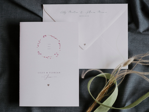 Schlichte und elegante Einladungskarte mit zarten Blütenblätter in Pink und silberner Prägung.
