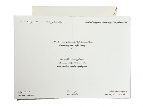 Edle Hochzeitseinladung auf hochwertigem Büttenpapier mit matt-gold geprägtem Herz und kalligrafischer Schrift, begleitet von einem creme-weißen Büttenumschlag mit dunkelblauem Innenfutter.