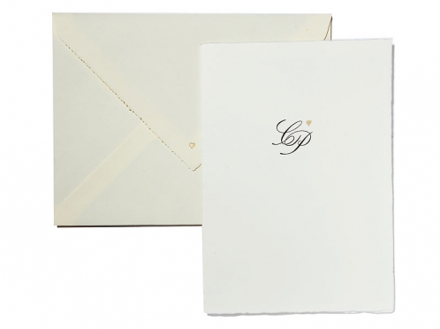Edle Hochzeitseinladung auf hochwertigem Büttenpapier mit matt-gold geprägtem Herz und kalligrafischer Schrift, begleitet von einem creme-weißen Büttenumschlag mit dunkelblauem Innenfutter.