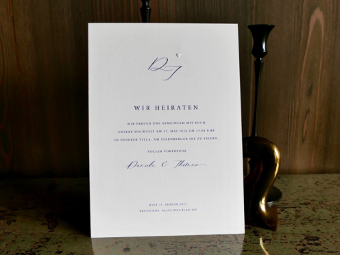 Hochzeitseinladungskarten in elegantem Blau mit Initialen und einem dezenten Herz als Blindprägung. Inklusive Umschlag mit edlem dunkelblauem Seidenfutter.