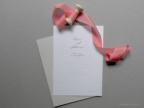 Die Save-The-Date Karten mit floraler Tiefprägung, gedruckt auf edlem Papier. Seidenband in Altrosa.