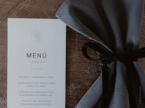 Schlichte Eleganz auf cremefarbenem Gmund Papier im DIN lang Format – die Cotton Grey Menükarte mit feiner Blindprägung passt ideal zu Ihrer Hochzeitstafel.