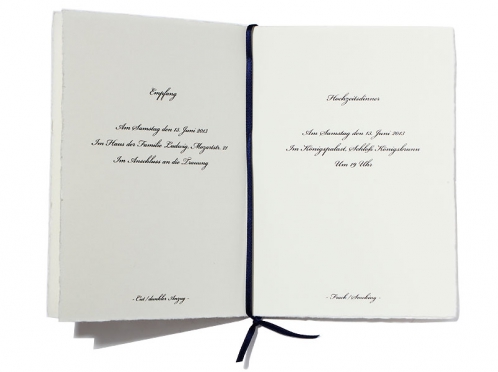 8-seitiges Programmheft, das Ihre Gäste mit allen Details zum Hochzeitsablauf vertraut macht. Veredelt mit einer edlen Goldprägung und verziert mit einem eleganten dunkelblauen Satinband, ab 20 Stück erhältlich.