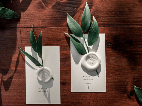 Elegante Tischkarten aus cremefarbenem Papier, personalisierbar als Tischkarten oder Escort Cards. Optional mit Siegelstempel (bitte getrennt bestellen).