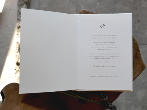 Hochwertige Hochzeitseinladung aufgeklappt. Der Einladungstext zur Hochzeit ist minimalistisch gestaltet.