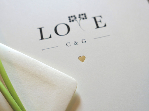 Detailaufnahme Heißfolienprägung Herz in Mattgold geprägt mit Love als typografisches Gestaltungselement.