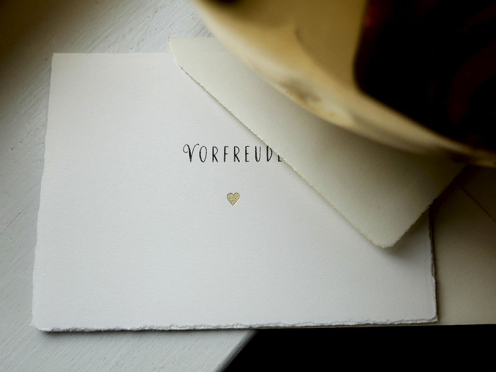 save-the-Date Karte mit gold geprägtem Herz und Rare Bird Font Typografie gedruckt auf Büttenpapier