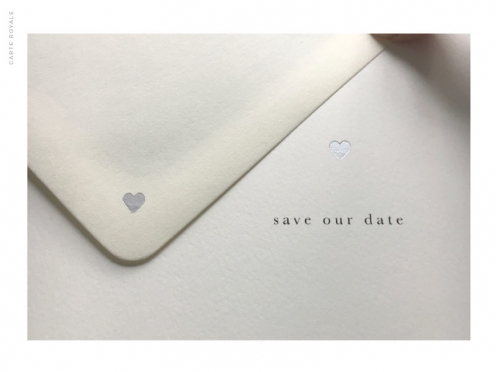 Beidseitg bedruckte Büttenpapier Save-the-Date Karte zur Hochzeit mit kleinen silbernen Herzen.