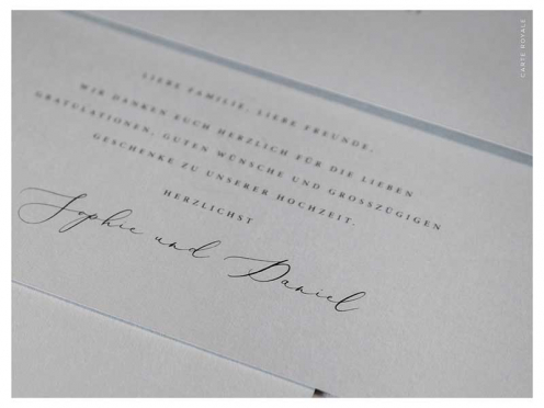 Hochzeitseinladung mit goldenen Initialen auf hochwertigem Papier in edlem Grau. Briefkuvert mit gold geprägtem Herz.