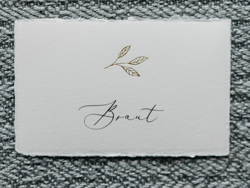 Hochwertige Tischkarten mit goldenem Zweig veredelt, handgefertigt und personalisiert mit dem Namen Ihres Gastes. Gedruckt und geprägt auf Büttenpapier.