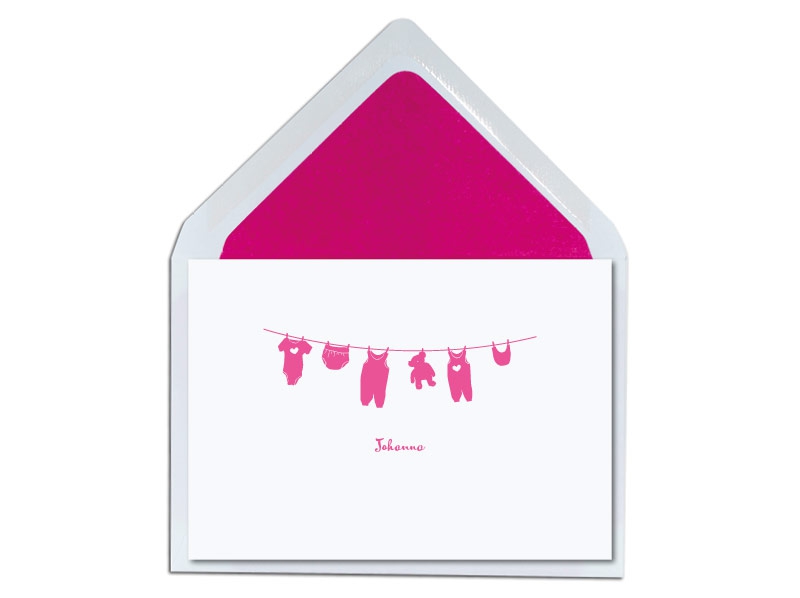 Geburtkarte mit hängenden Babykleider und pink gefüttertem Briefumschlag.