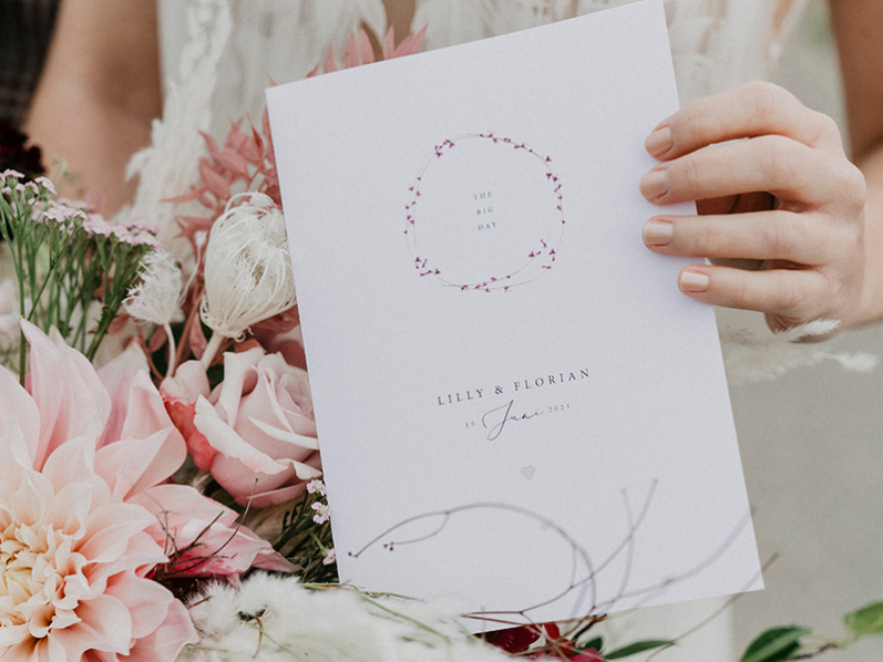 Schlichte und elegante Einladungskarte mit zarten Blütenblätter in Pink und silberner Prägung.
